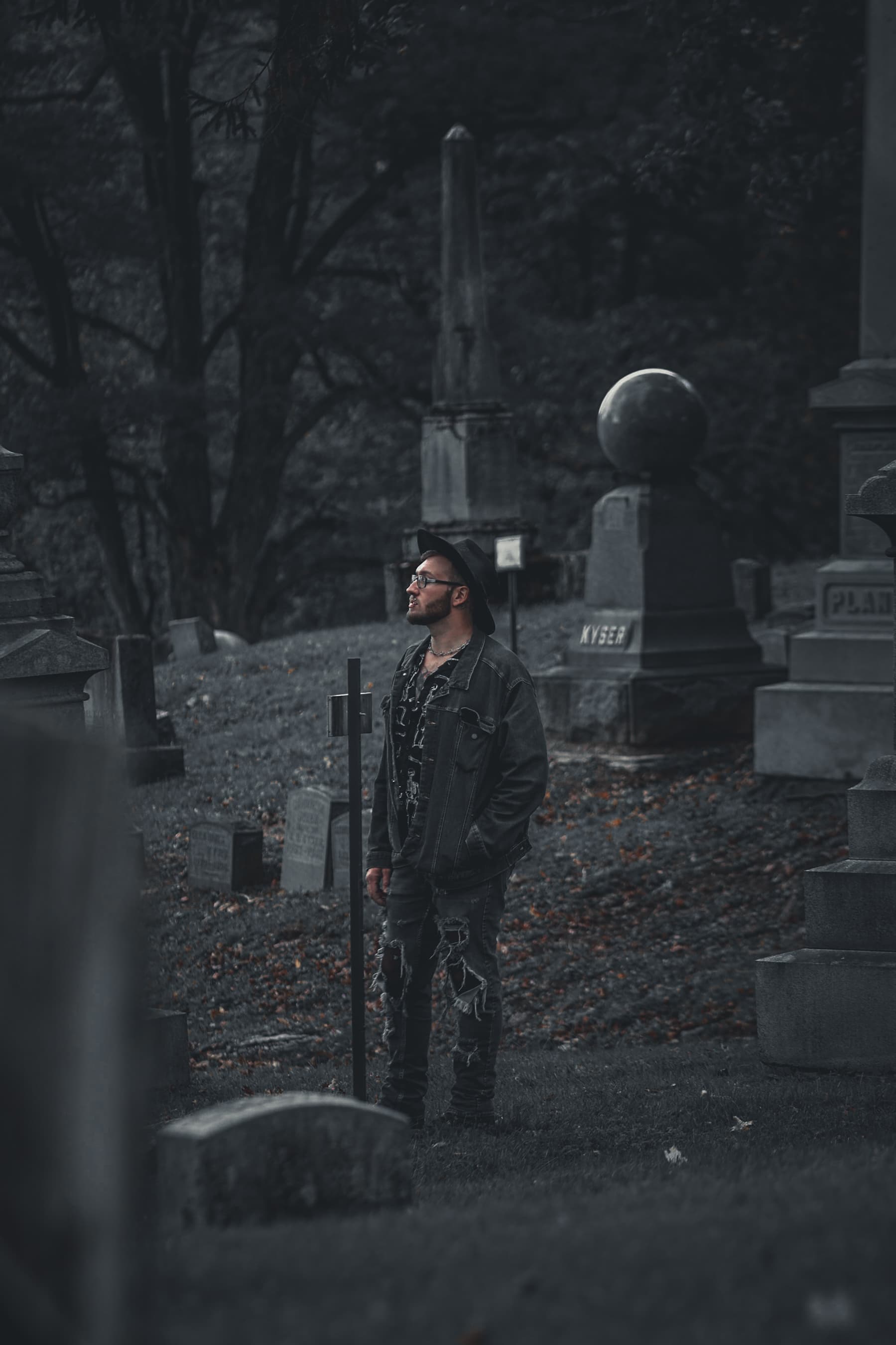Man standing in cemetery with moody tones